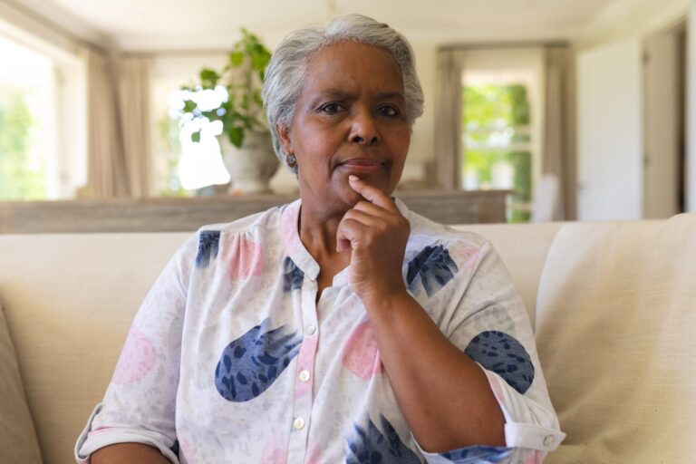 portrait-senior-african-american-woman-sitting-sofa-looking-camera-scaled.jpg