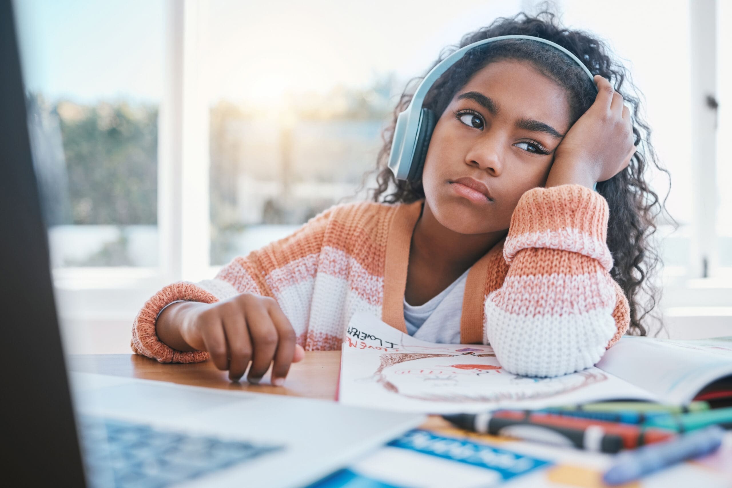 child-headphones-girl-tired-home-school-e-learning-future-online-education-thinking-bored-kid-with-adhd-autism-sad-laptop-while-drawing-listening-audio-table-scaled.jpg