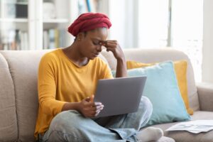 exhausted-young-black-woman-using-computer-home-feeling-tired-scaled.jpg